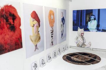 Installation artistique dans une école d'art avec photos de personnages costumés.